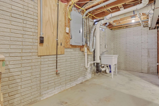 basement featuring brick wall and electric panel