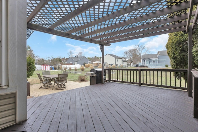 wooden deck with grilling area, a yard, a pergola, and a patio area