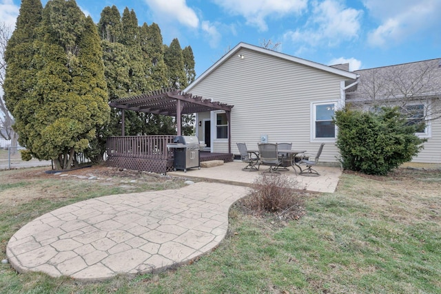 rear view of property featuring a yard, a pergola, and a patio