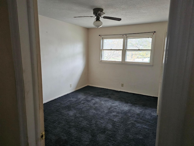 spare room with a textured ceiling, ceiling fan, and dark carpet