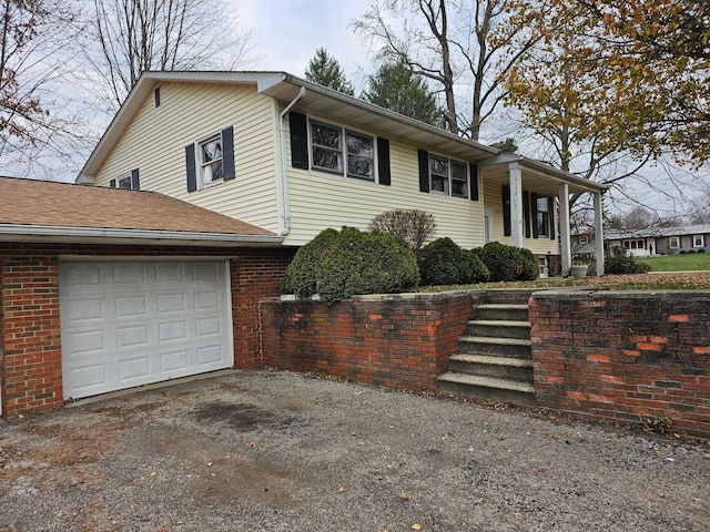 view of front facade featuring a garage, driveway, brick siding, and a shingled roof