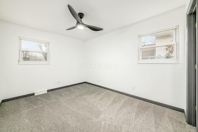 carpeted spare room featuring ceiling fan