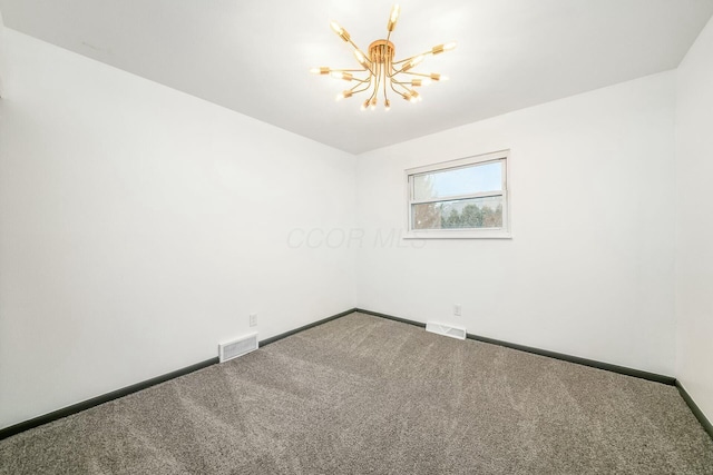 carpeted empty room with an inviting chandelier