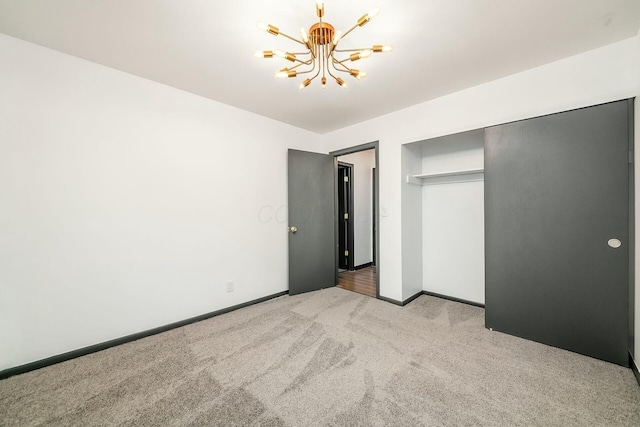 unfurnished bedroom with light carpet, a closet, and a chandelier