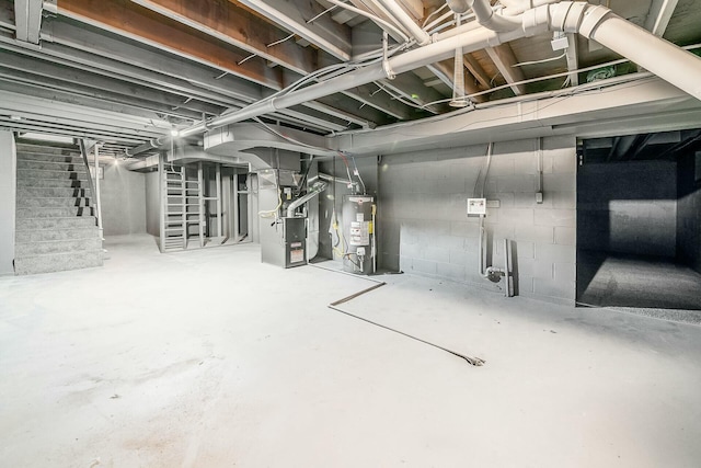 basement featuring heating unit and water heater