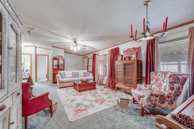 living room with ornamental molding, carpet flooring, ceiling fan, and a textured ceiling