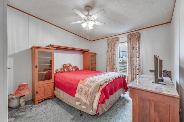 carpeted bedroom with crown molding, ceiling fan, and a textured ceiling