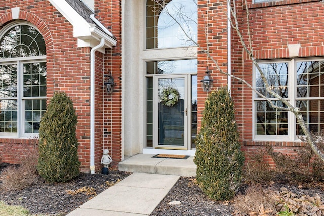 entrance to property featuring brick siding