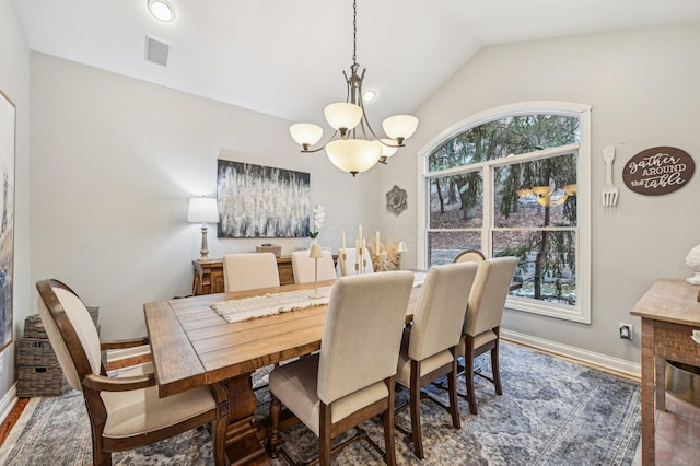 dining area featuring lofted ceiling, dark hardwood / wood-style floors, and an inviting chandelier