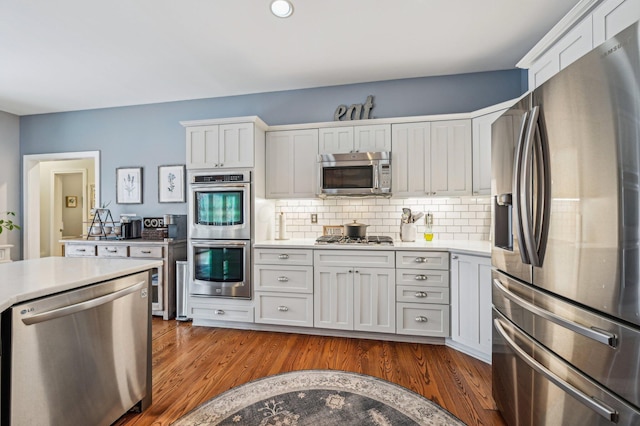 kitchen featuring wood-type flooring, white cabinets, and appliances with stainless steel finishes