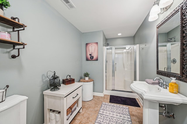 bathroom with an enclosed shower, tile patterned floors, and toilet