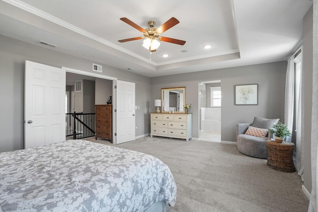 bedroom with ensuite bath, light carpet, ornamental molding, a tray ceiling, and ceiling fan