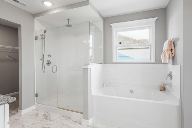 bathroom with vanity and shower with separate bathtub