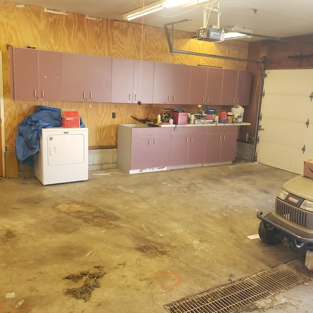 garage featuring a garage door opener and washer / dryer