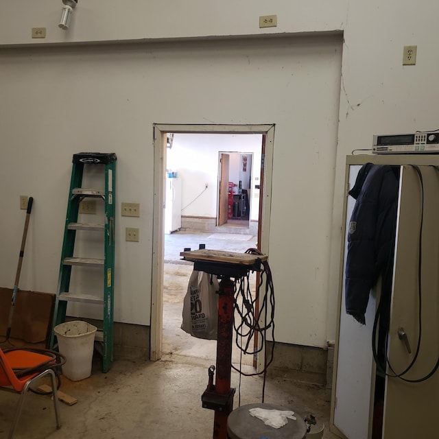 corridor with concrete flooring and washer / dryer