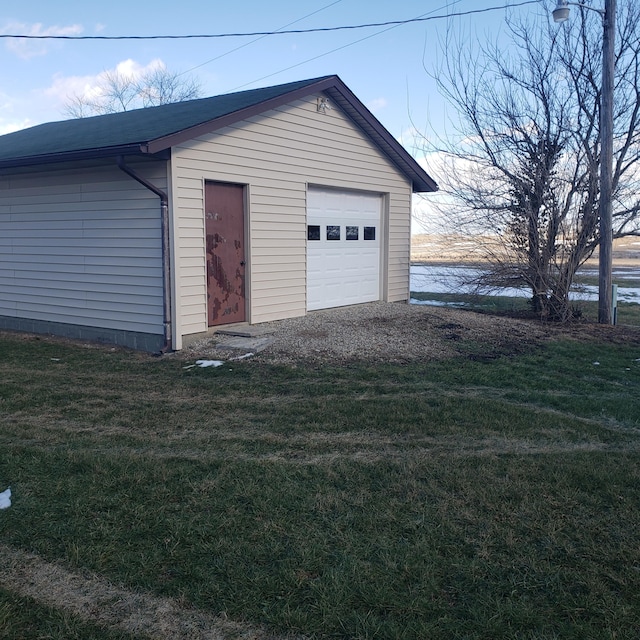 garage featuring a water view and a lawn