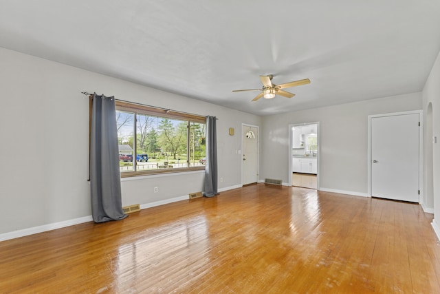 empty room featuring visible vents, a ceiling fan, baseboards, and a healthy amount of sunlight