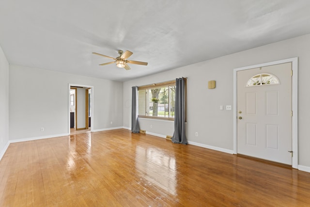 foyer entrance featuring baseboards, light wood finished floors, and ceiling fan