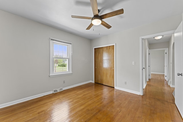 unfurnished bedroom with baseboards, a closet, and light wood-type flooring