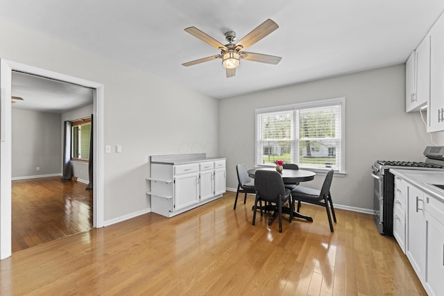 dining area with ceiling fan, baseboards, and light wood finished floors
