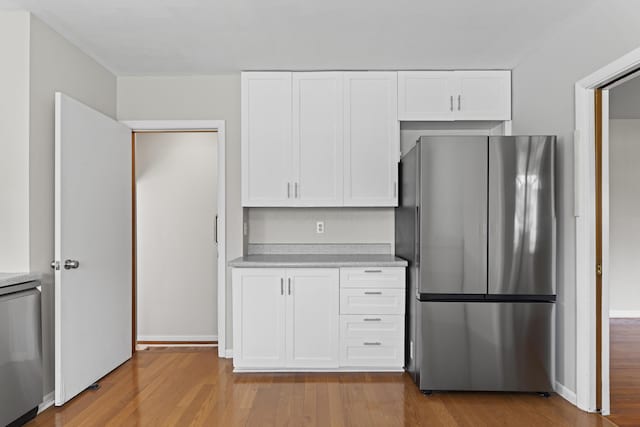 kitchen with light wood-style floors, freestanding refrigerator, and light countertops
