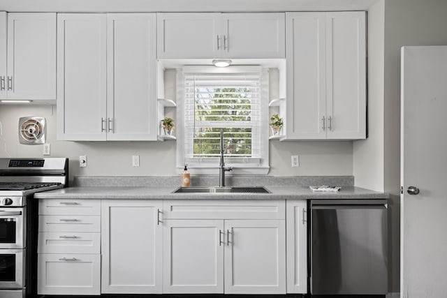 kitchen featuring white cabinets, a sink, light countertops, stainless steel appliances, and visible vents