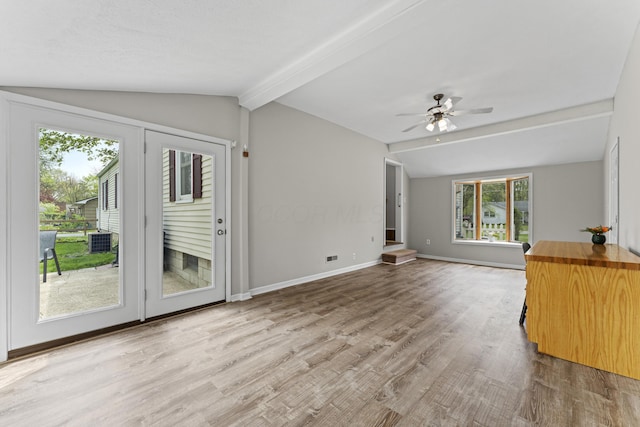 unfurnished living room with a ceiling fan, lofted ceiling with beams, plenty of natural light, and wood finished floors