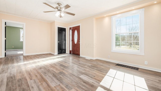 unfurnished room with ceiling fan, a healthy amount of sunlight, and light wood-type flooring