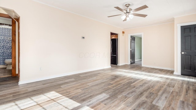 empty room featuring hardwood / wood-style flooring, ornamental molding, and ceiling fan