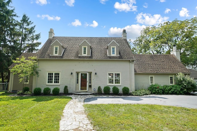 cape cod-style house featuring a front yard