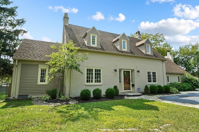 new england style home featuring a front lawn