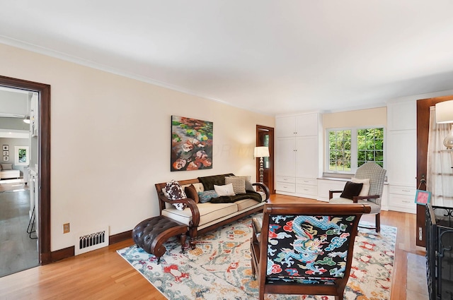 living room featuring crown molding and light wood-type flooring