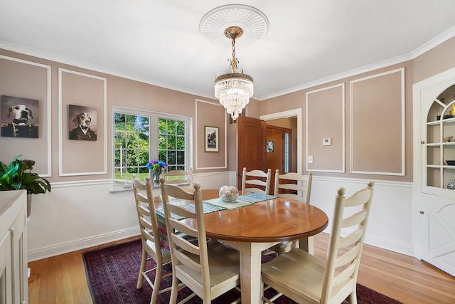 dining room featuring a notable chandelier, crown molding, and wood-type flooring