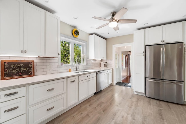 kitchen with tasteful backsplash, white cabinetry, appliances with stainless steel finishes, and sink