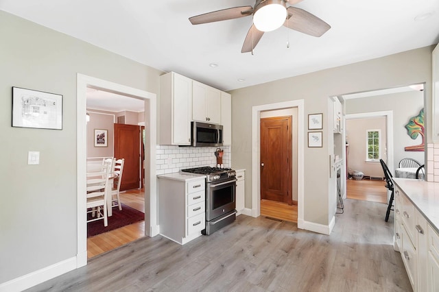 kitchen featuring ceiling fan, stainless steel appliances, tasteful backsplash, white cabinets, and light wood-type flooring