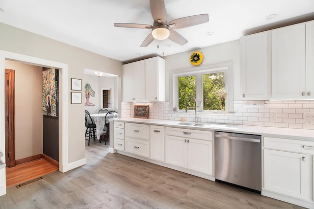 kitchen featuring dishwasher, white cabinets, backsplash, ceiling fan, and light wood-type flooring