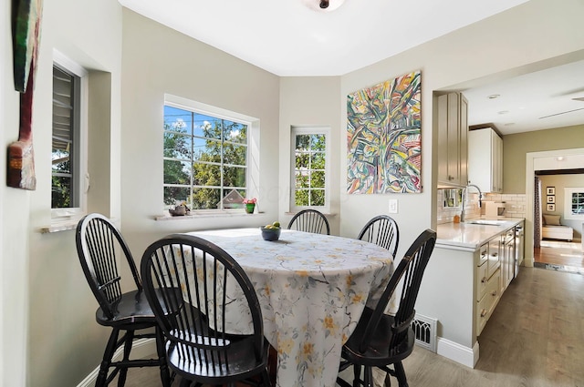 dining area with light hardwood / wood-style floors and sink