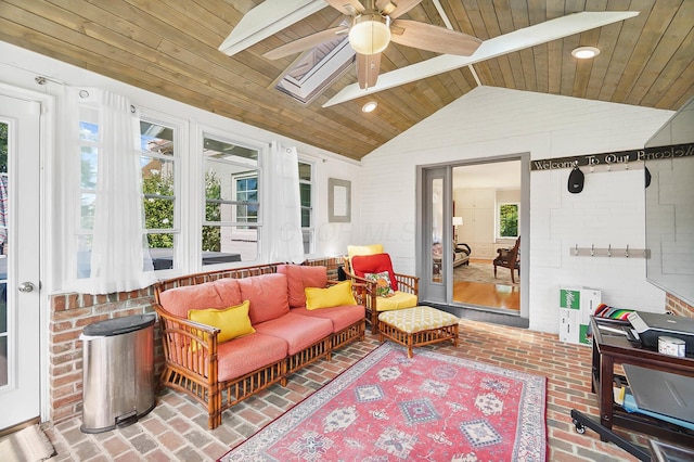 sunroom featuring wood ceiling, lofted ceiling with skylight, and ceiling fan