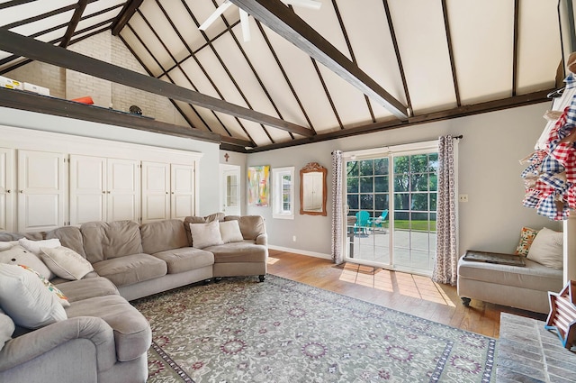 living room featuring beamed ceiling, high vaulted ceiling, and light wood-type flooring