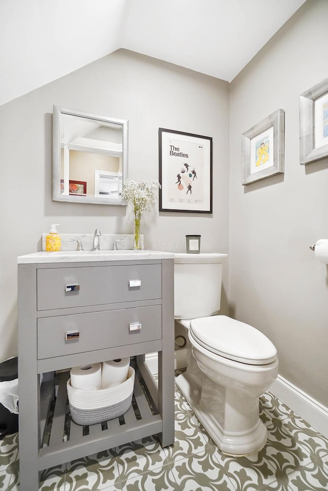 bathroom featuring vanity, vaulted ceiling, and toilet