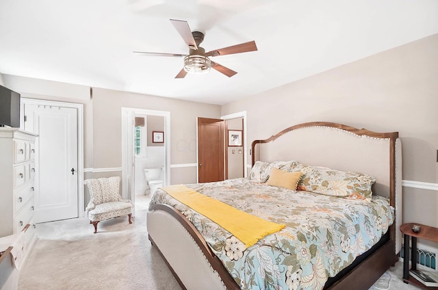 bedroom with ensuite bathroom, carpet floors, and ceiling fan