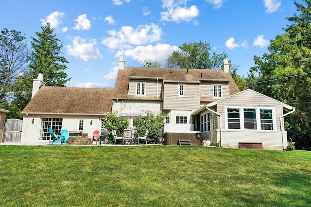 back of house featuring a hot tub, a patio, and a yard