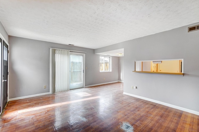 unfurnished living room with hardwood / wood-style floors and a textured ceiling