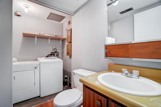 bathroom with vanity, toilet, and washer and dryer