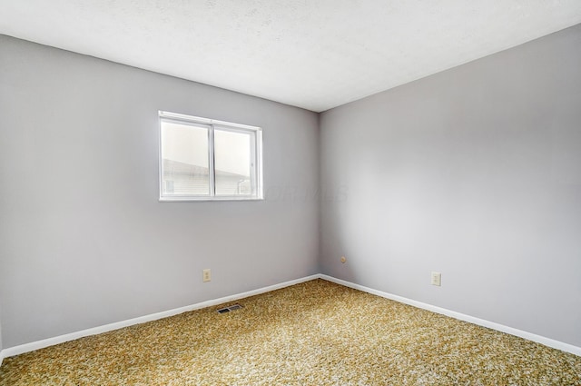 carpeted spare room with a textured ceiling