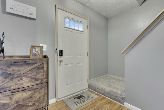 foyer with light hardwood / wood-style floors and a textured ceiling