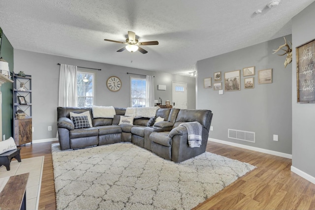 living room featuring hardwood / wood-style floors, a textured ceiling, and ceiling fan