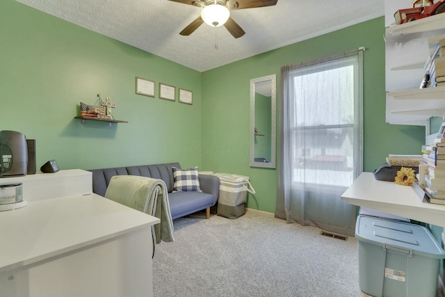 bedroom featuring light carpet, ceiling fan, and a textured ceiling