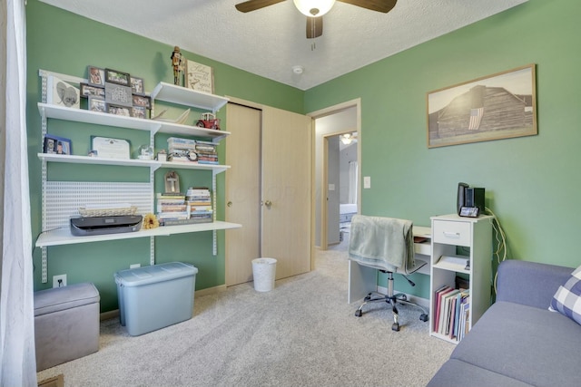 carpeted office with ceiling fan and a textured ceiling