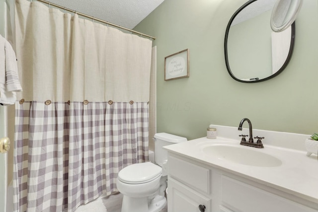 bathroom featuring vanity, a textured ceiling, and toilet